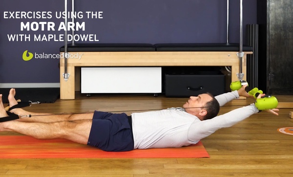 exercises using the motr arm with maple dowel man exercising on mat